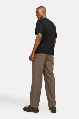 Man met zwarte T-shirt, olijfgroene broek en zwarte schoenen.