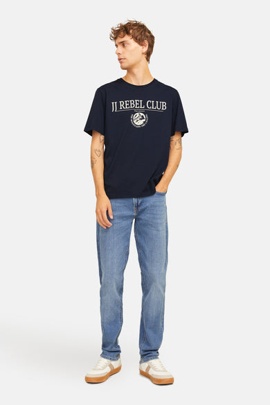 Blauw T-shirt met korte mouwen van JJREBEL, met witte opdruk, gecombineerd met een jeans en sneakers.