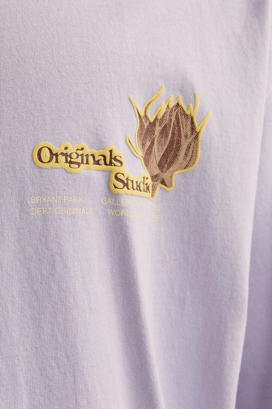 Lila shirt met gele en bruine opdruk.