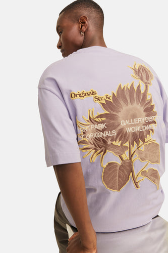 Een man met paarse T-shirt met zonnebloem motief.