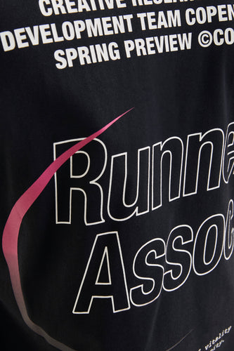 Zwart t-shirt met witte tekst en roze accenten.