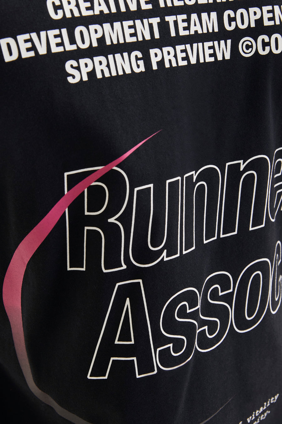 Zwart t-shirt met witte tekst en roze accenten.