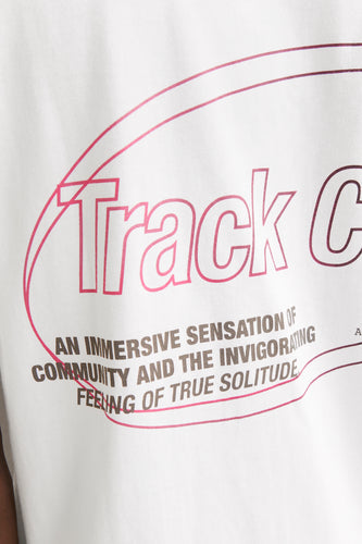 Wit T-shirt met roze "Track C" opdruk en tekst.