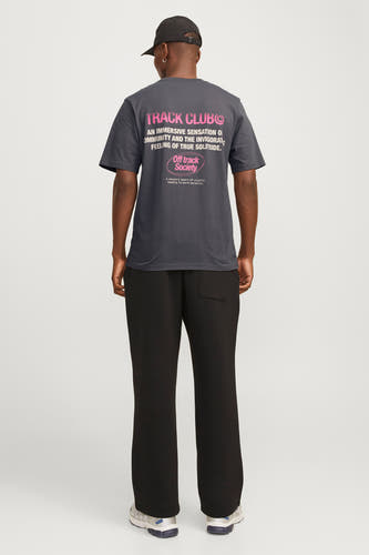 T-shirt violet à manches courtes de CORE BY JACK & JONES, avec une impression de texte rose sur le dos, porté avec un pantalon noir.