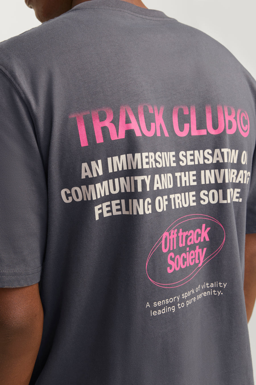 Donkergrijs T-shirt met roze en witte tekstprint op de rug.