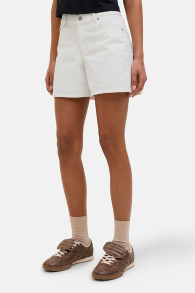 Short blanc de JJXX, porté avec des chaussettes beige et des chaussures en cuir marron.