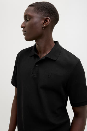 Polo noir à manches courtes de CORE BY JACK & JONES, avec un fin motif à carreaux et un logo subtil.