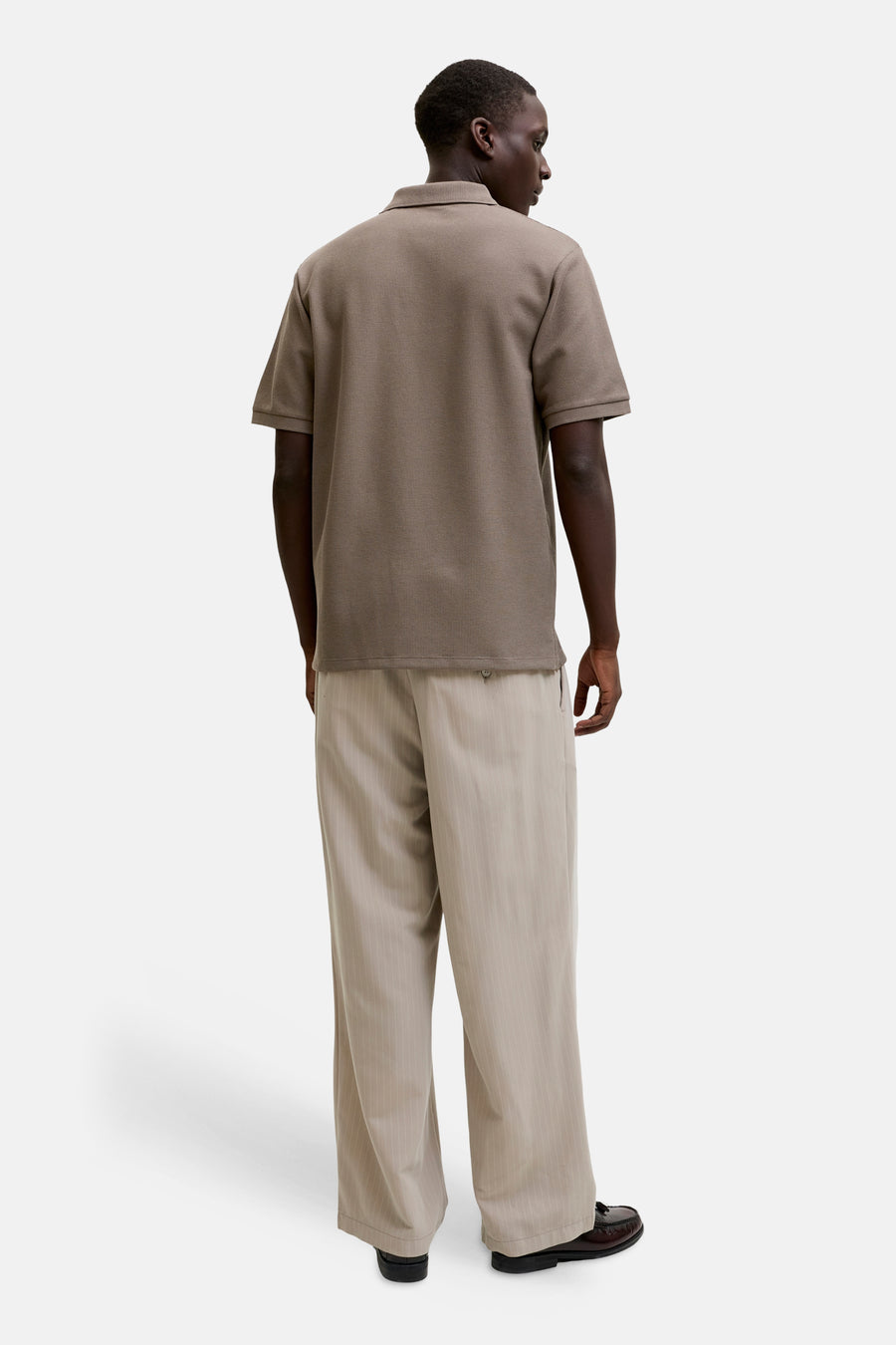 Polo marron de CORE BY JACK & JONES, dos à manches courtes et combiné avec un pantalon rayé.