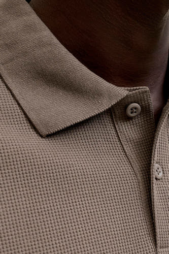 Polo marron de CORE BY JACK & JONES, avec une subtile texture gaufrée et un col et des boutons visibles.