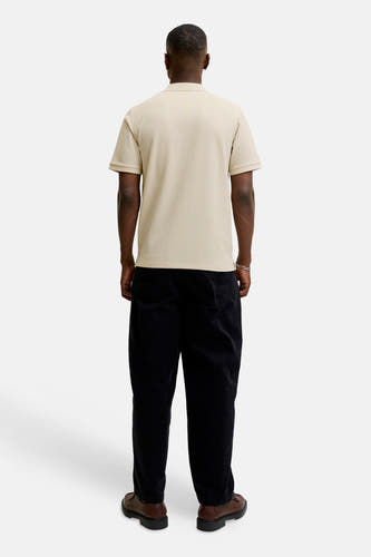 Polo beige à manches courtes de CORE BY JACK & JONES, porté avec un pantalon marron et des chaussures noires.
