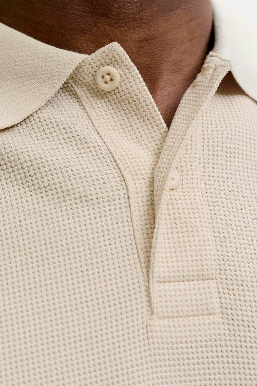 Polo beige à manches courtes de CORE BY JACK & JONES, avec structure gaufrée, boutons de couleur crème et patte de boutonnage partiellement ouverte.