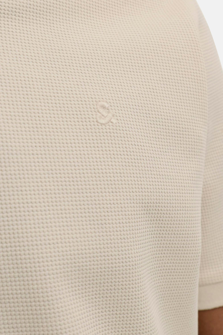 Polo beige à manches courtes de CORE BY JACK & JONES, avec structure gaufrée et logo brodé, porté par un mannequin.