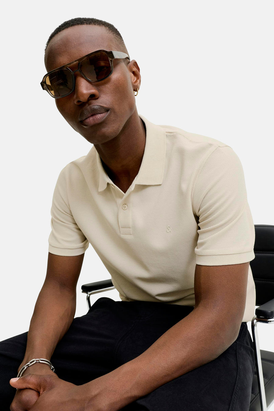 Beige polo met korte mouwen van CORE BY JACK & JONES, met wafelstructuur en geborduurd logo, gedragen door een model.