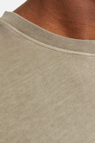 T-shirt vert de mantes courtes CORE BY JACK & JONES, gros plan sur l'encolure et une peau brune.
