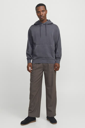 Sweat à capuche gris de CORE BY JACK & JONES avec cordons de serrage et poche kangourou, porté par un mannequin avec un pantalon ample marron et des chaussures en daim noires.
