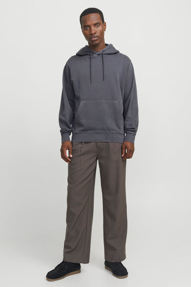 Sweat à capuche gris de CORE BY JACK & JONES avec cordons de serrage et poche kangourou, porté par un mannequin avec un pantalon ample marron et des chaussures en daim noires.