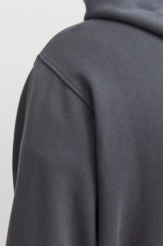 Sweat à capuche gris de CORE BY JACK & JONES avec texture côtelée visible et couture d'épaule en gros plan.