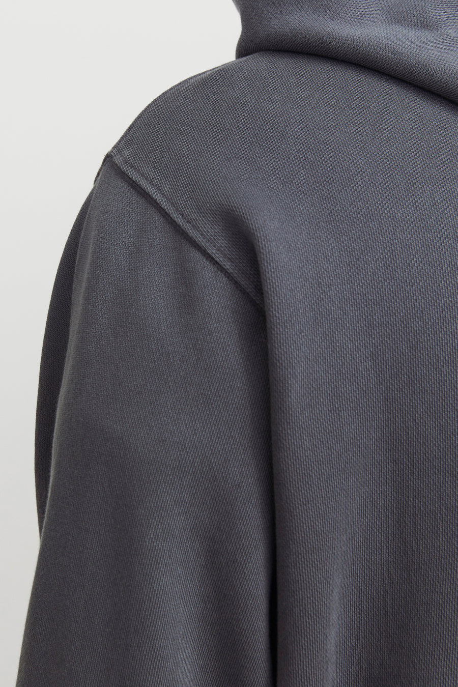 Sweat à capuche gris de CORE BY JACK & JONES avec texture côtelée visible et couture d'épaule en gros plan.