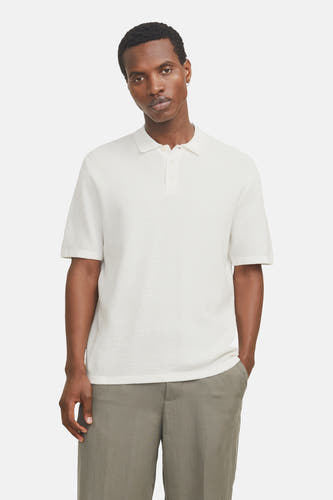 Pull blanc de CORE BY JACK & JONES, à manches courtes, porté avec un pantalon vert et des chaussures crème.