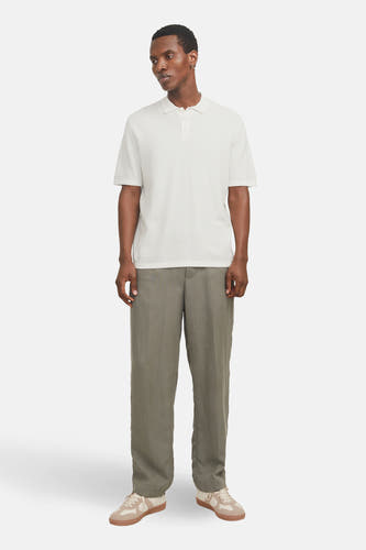 Witte trui van CORE BY JACK & JONES, met korte mouwen, gedragen met groene broek en crèmekleurige schoenen.