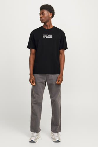 Zwart T-shirt met korte mouwen van CORE by JACK & JONES, gedragen met grijze broek en witte sneakers.