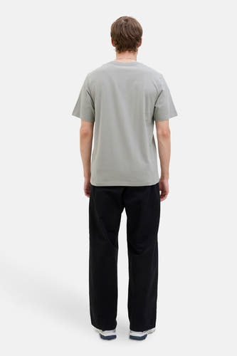 T-shirt gris à manches courtes de CORE BY JACK & JONES, dos, avec un pantalon noir et des baskets blanches.