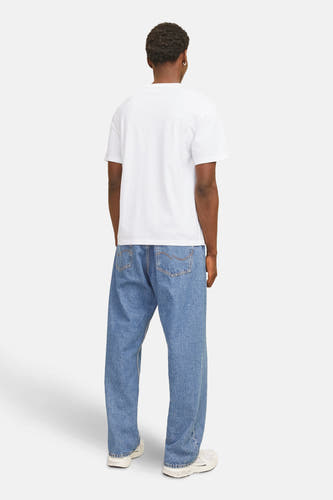 T-shirt blanc à manches courtes de CORE by JACK & JONES, avec logo sur la poitrine et porté avec des jeans foncés.