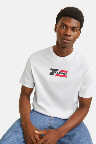 T-shirt blanc à manches courtes de CORE par JACK & JONES, avec un petit logo sur la poitrine et porté avec un jean foncé.