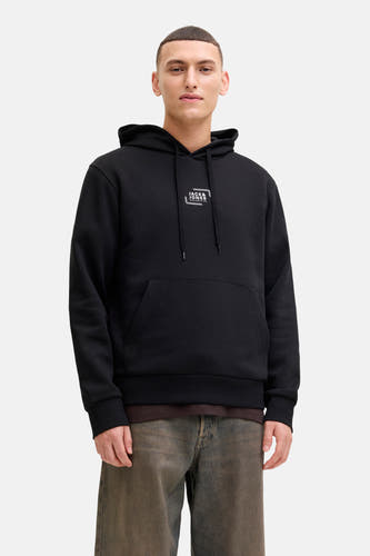 Pull-over noir avec capuche de CORE par JACK & JONES, avec des cordons et une poche kangourou, porté avec un t-shirt marron et un jean.