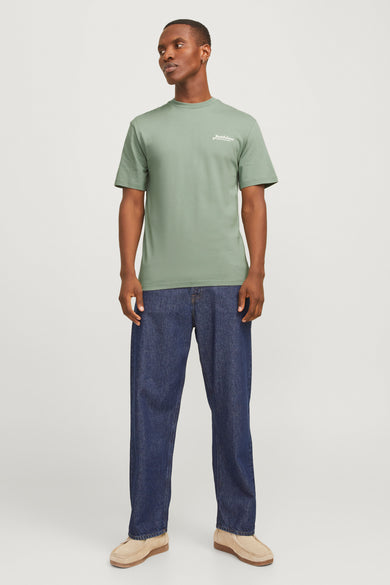 T-shirt vert avec manches courtes d'ORIGINALS par JACK & JONES, associé à des jeans bleu marine et des chaussures en cuir de suède.