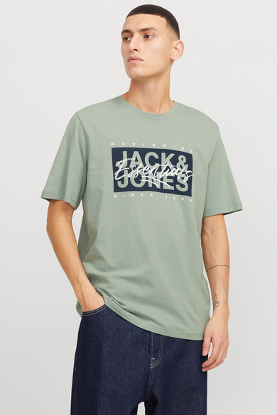 Groen T-shirt met korte mouwen van ORIGINALS BY JACK & JONES, met een logo op de voorkant, gedragen met donkere jeans.
