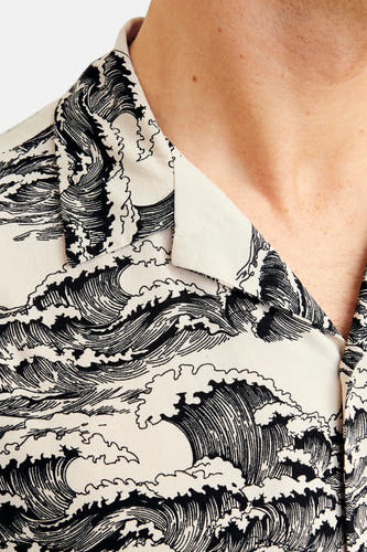 Chemise noire à manches courtes de CORE BY JACK & JONES, avec un motif ondulé sur le tissu.