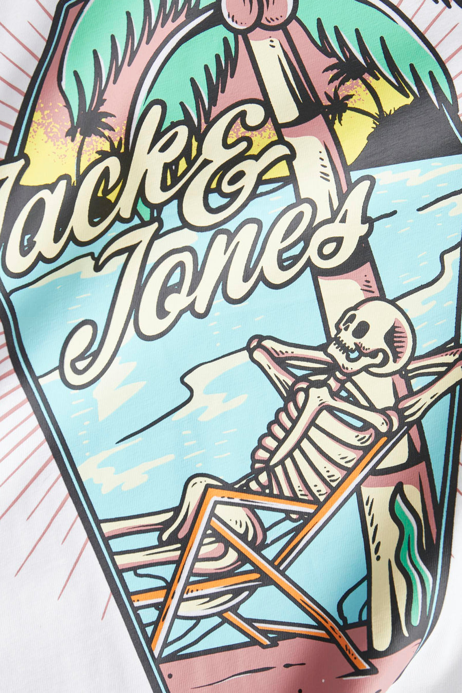 Print met "Jack & Jones" op een T-shirt met skelet in strandstoel.