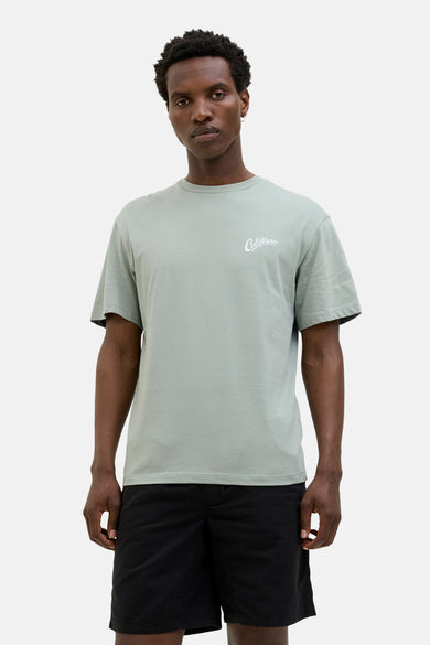 T-shirt vert de mantes courtes courSSSSS & J J,éééé avec shorts noirs et des chaussettes blanches.