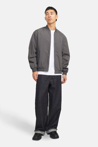Manteau gris court de PREMIUM par JACK & JONES, porté sur un T-shirt blanc avec des jeans foncés larges et des chaussures noires.