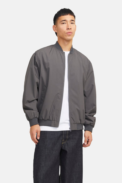 Manteau gris court de PREMIUM par JACK & JONES, avec des manches longues et un T-shirt blanc et un pantalon foncé.