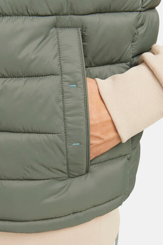 Gilet bodywarmer de PREMIUM BLUE par JACK & JONES, avec poche main et une trui beige.