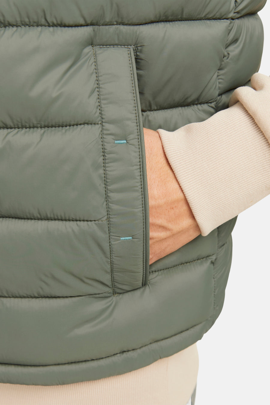 Gilet bodywarmer de PREMIUM BLUE par JACK & JONES, avec poche main et une trui beige.