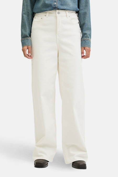 Jean en denim blanc cassé large de JJXX, associé à un t-shirt en denim bleu, vu de face.