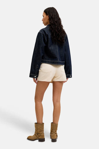 Skort écru de JJXX, combiné avec une veste en jean bleu foncé et des bottines marron.