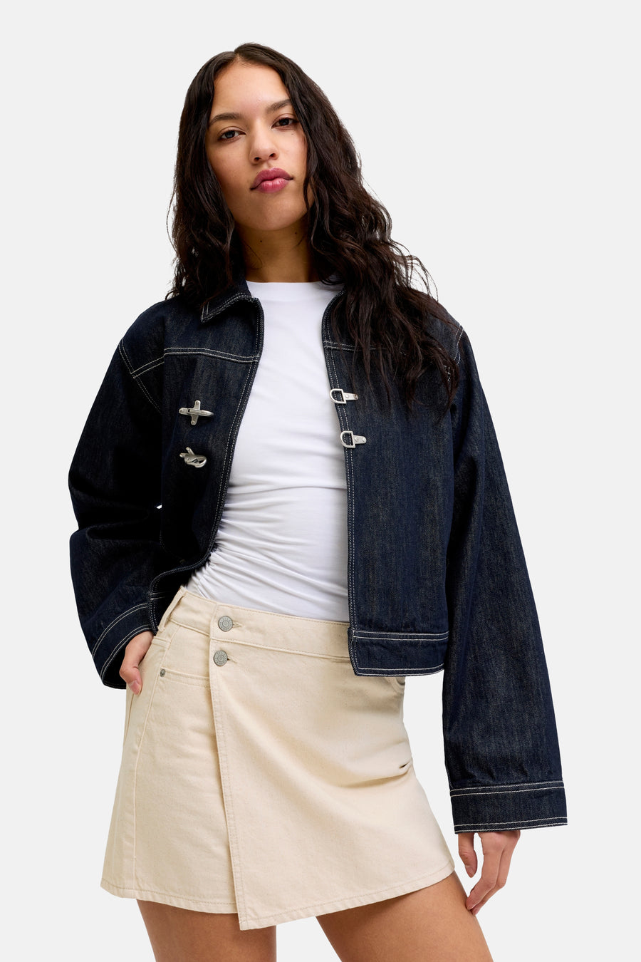 Skort écru de JJXX, avec détail portefeuille et fermeture à boutons visible, combiné avec un t-shirt blanc et une veste en jean bleu foncé.