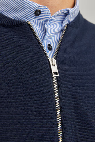 Veste bleue d'ORIGINALS BY JACK & JONES avec fermeture à glissière argentée sur un chemisier rayé.