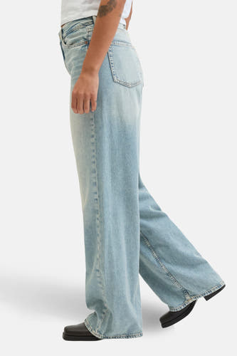 Jean en denim bleu clair large de JJXX, avec des jambes larges et des chaussures noires.