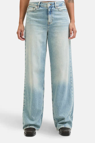 Jean en denim bleu clair de JJXX, avec des poches arrière et une étiquette en cuir sur la ceinture.