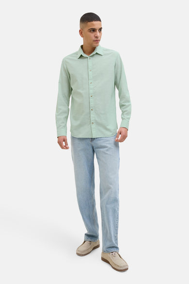Chemise verte à manches longues de PREMIUM by JACK & JONES, portée avec des jeans bleu clair et des chaussures en cuir.
