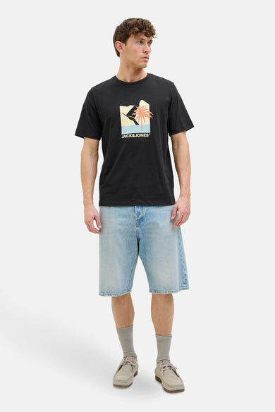 T-shirt noir à manches courtes d'ORIGINALS BY JACK & JONES, avec une impression graphique, porté avec des shorts en denim.