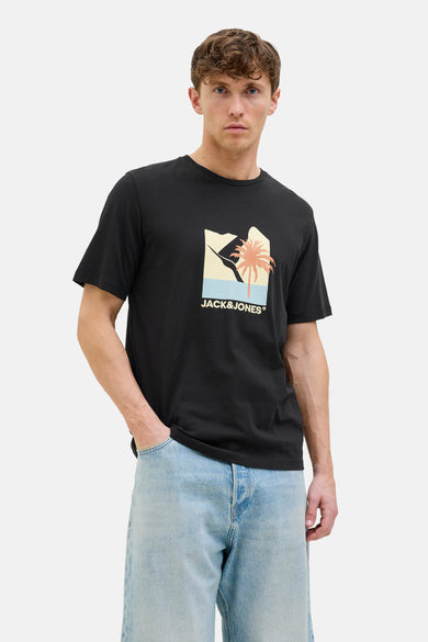 T-shirt noir à manches courtes d'ORIGINALS BY JACK & JONES, avec une impression de palmier et de montagnes, associé à des jeans légers.