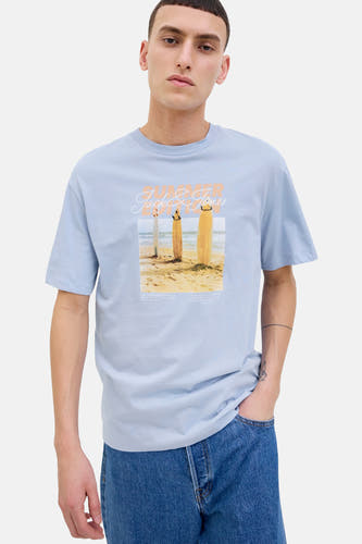 T-shirt bleu à manches courtes d'ORIGINALS BY JACK & JONES, avec une image de plage sur l'avant, porté avec des jeans.