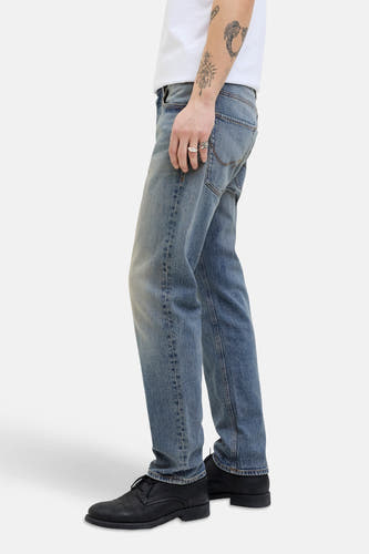 Jean en denim bleu tapered de JACK & JONES JEANS INTELLIGENCE, avec un peu de bagues et des chaussures noires.