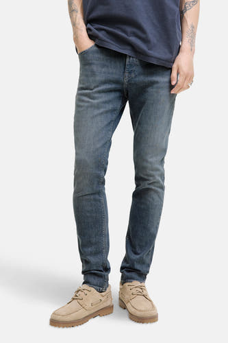 Jean slim de JACK & JONES JEANS INTELLIGENCE, en denim gris moyen, avec des chaussures marron clair.